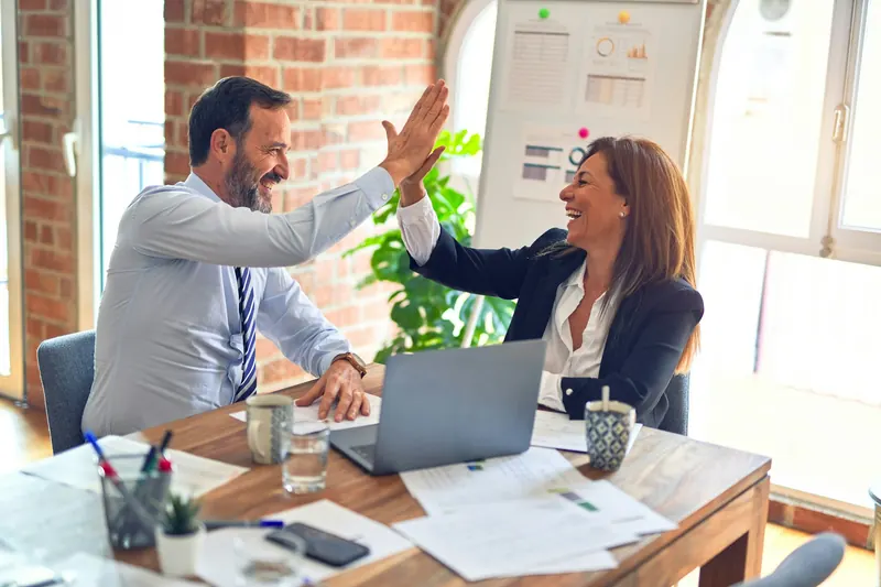 Two colleagues celebrating a successful meeting with a high five