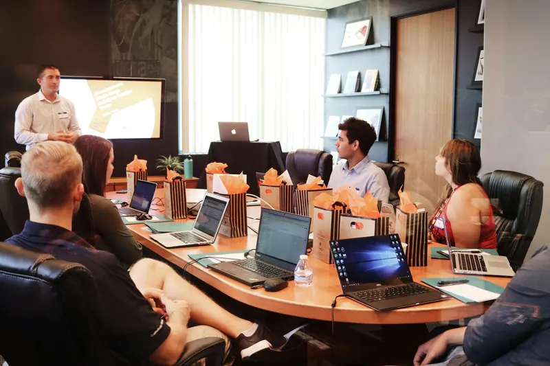 A facilitator presenting to a team around a large meeting table