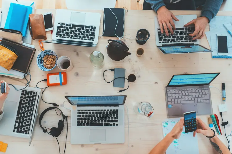 Overhead view of a team working on laptops around a shared table