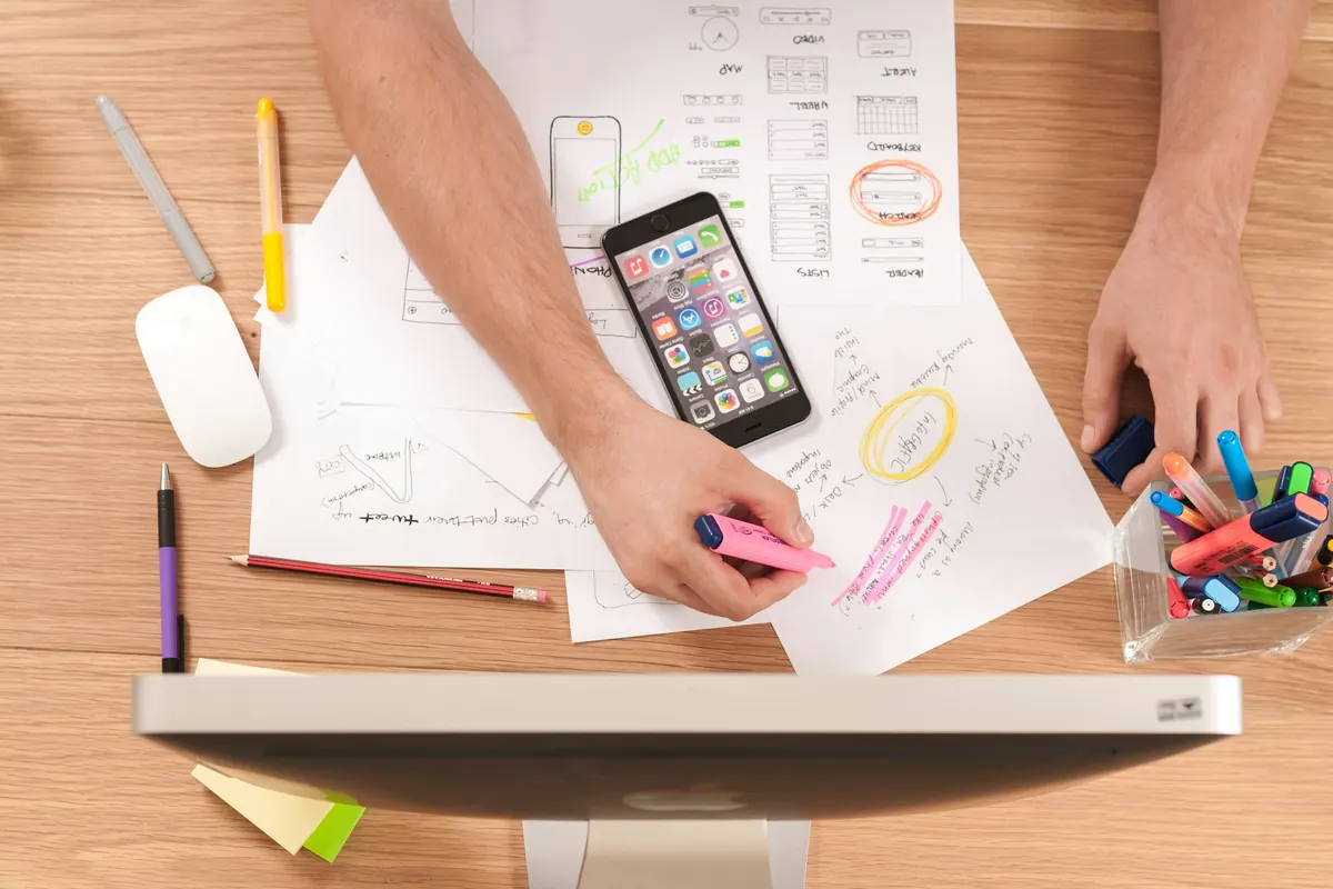 Desk with a smartphone, notes and a mouse during content planning